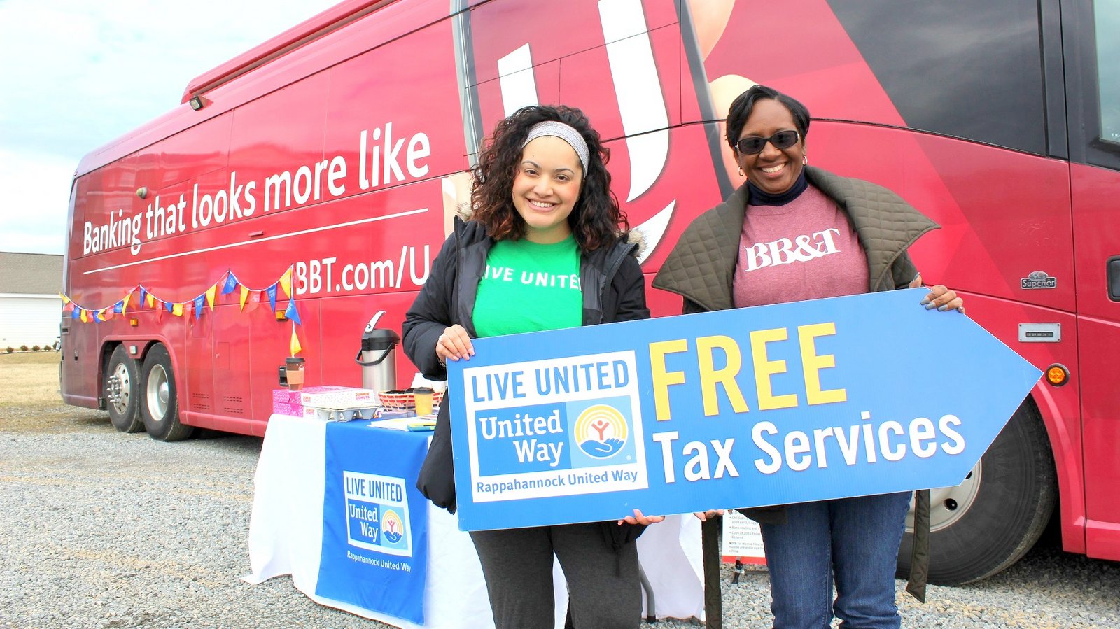 Smiling tax volunteers posing in front of the BB&T mobile tax prep bus